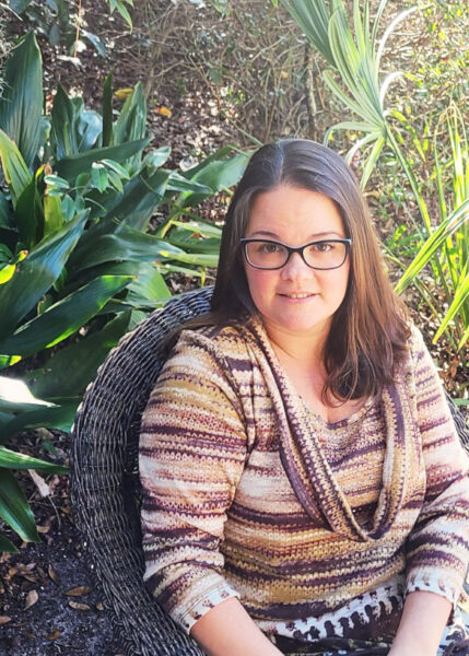 Photo of Christine Allmand sitting in a Chair in a Sunny Outdoor Garden